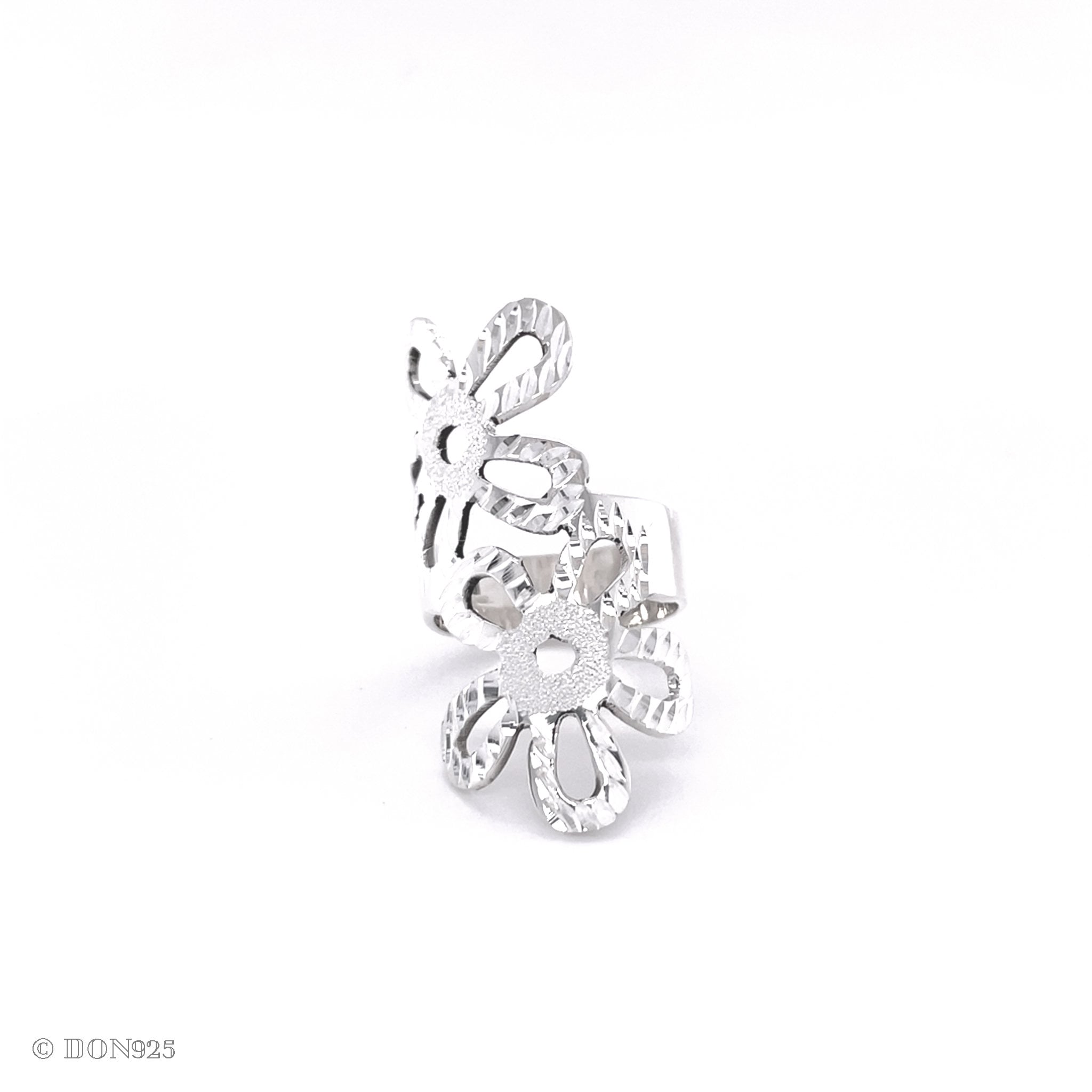 A silver ring with a floral design. The ring is made of two overlapping flowers with a textured surface.